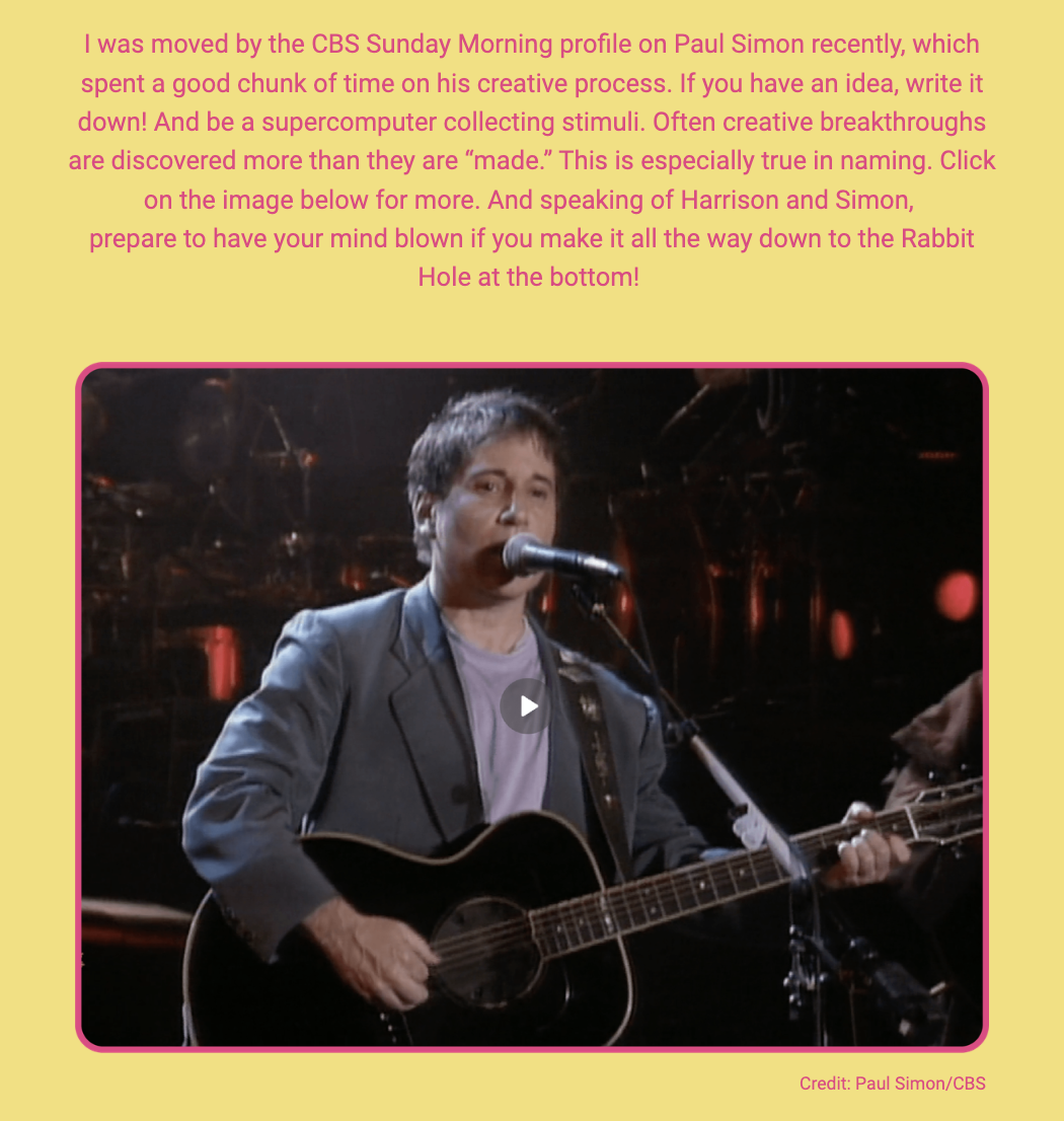 The image displays a screenshot of a video featuring Paul Simon performing, with a text overlay and a caption. Here is the alt text including all of the text that appears in the image:

"A screenshot of musician Paul Simon, captured mid-performance with a guitar, against a concert stage backdrop. He appears to be singing into a microphone. A play button overlay suggests it's a still from a video. The text above the image reads: 'I was moved by the CBS Sunday Morning profile on Paul Simon recently, which spent a good chunk of time on his creative process. If you have an idea, write it down! And be a supercomputer collecting stimuli. Often creative breakthroughs are discovered more than they are “made.” This is especially true in naming. Click on the image below for more. And speaking of Harrison and Simon, prepare to have your mind blown if you make it all the way down to the Rabbit Hole at the bottom!' The image is framed with a pink border and the credit at the bottom reads: 'Credit: Paul Simon/CBS'."