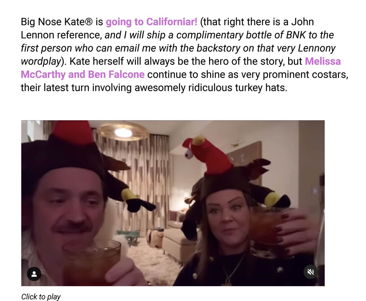 
The image is a screenshot of a social media post featuring two people wearing turkey hats. The text in the image reads:

"Big Nose Kate® is going to Californiar! (that right there is a John Lennon reference, and I will ship a complimentary bottle of BNK to the first person who can email me with the backstory on that very Lennony wordplay). Kate herself will always be the hero of the story, but Melissa McCarthy and Ben Falcone continue to shine as very prominent costars, their latest turn involving awesomely ridiculous turkey hats.

Click to play"

The people in the image are toasting with drinks in their hands, smiling at the camera, and seem to be in a festive or celebratory mood.